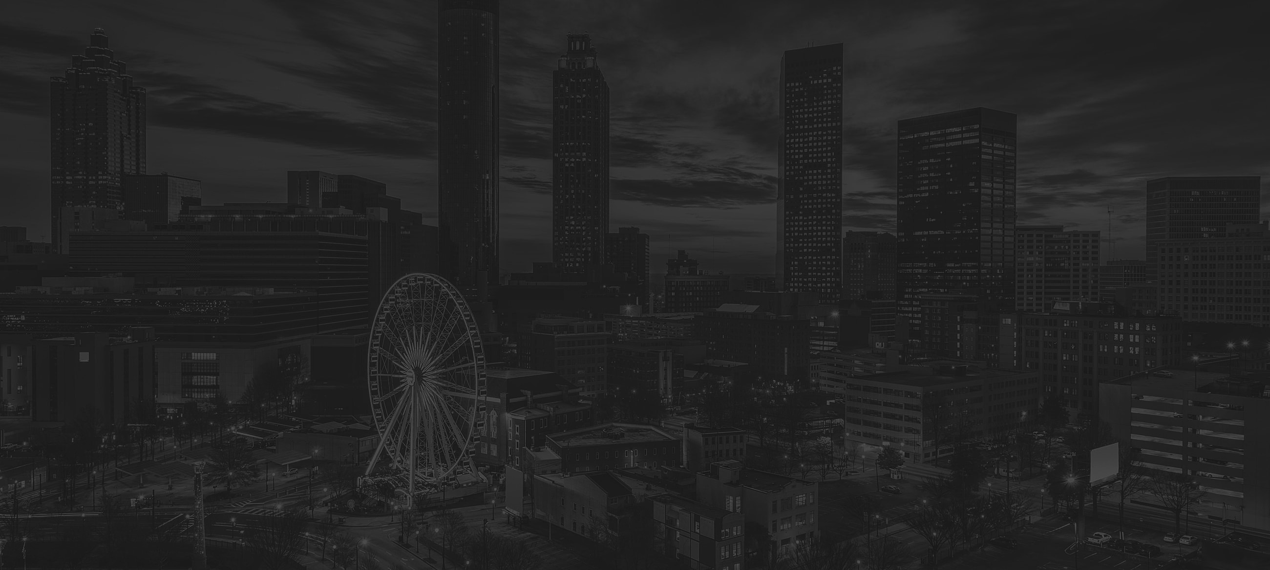 Atlanta skyline at night with Ferris wheel.
