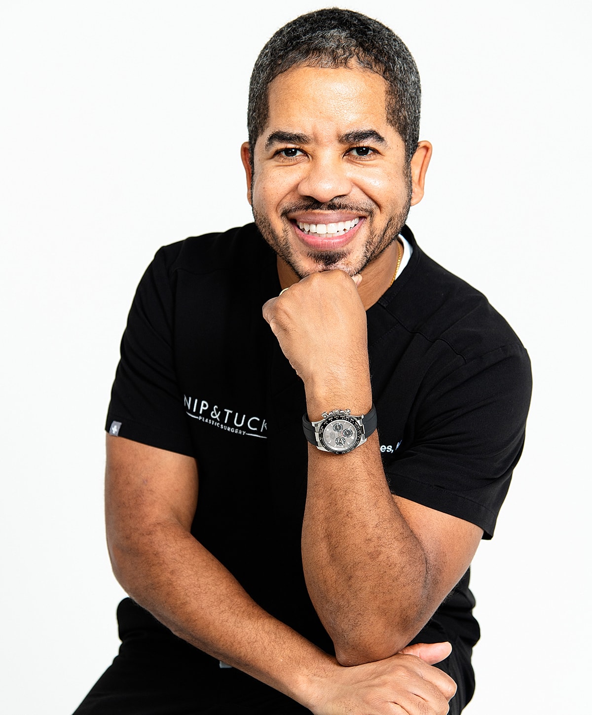 Smiling man in a black shirt, posing thoughtfully.