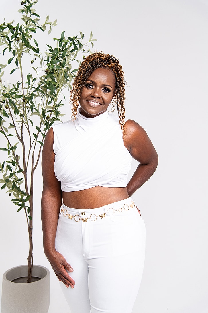 Woman in white outfit with potted plant.