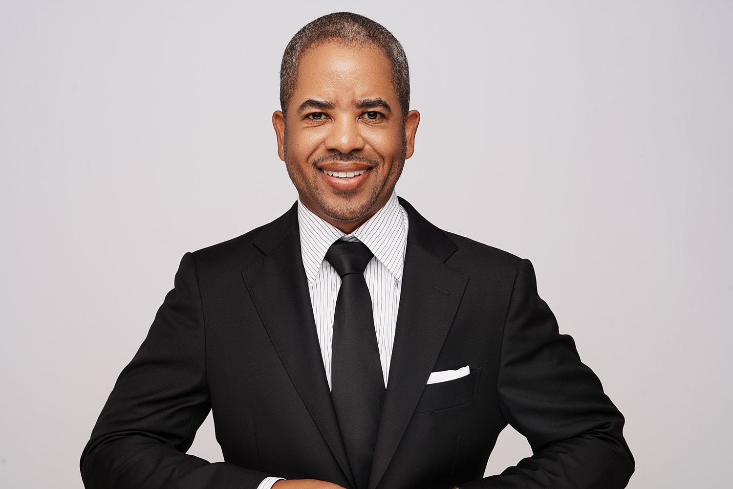 Smiling man in a formal suit and tie.
