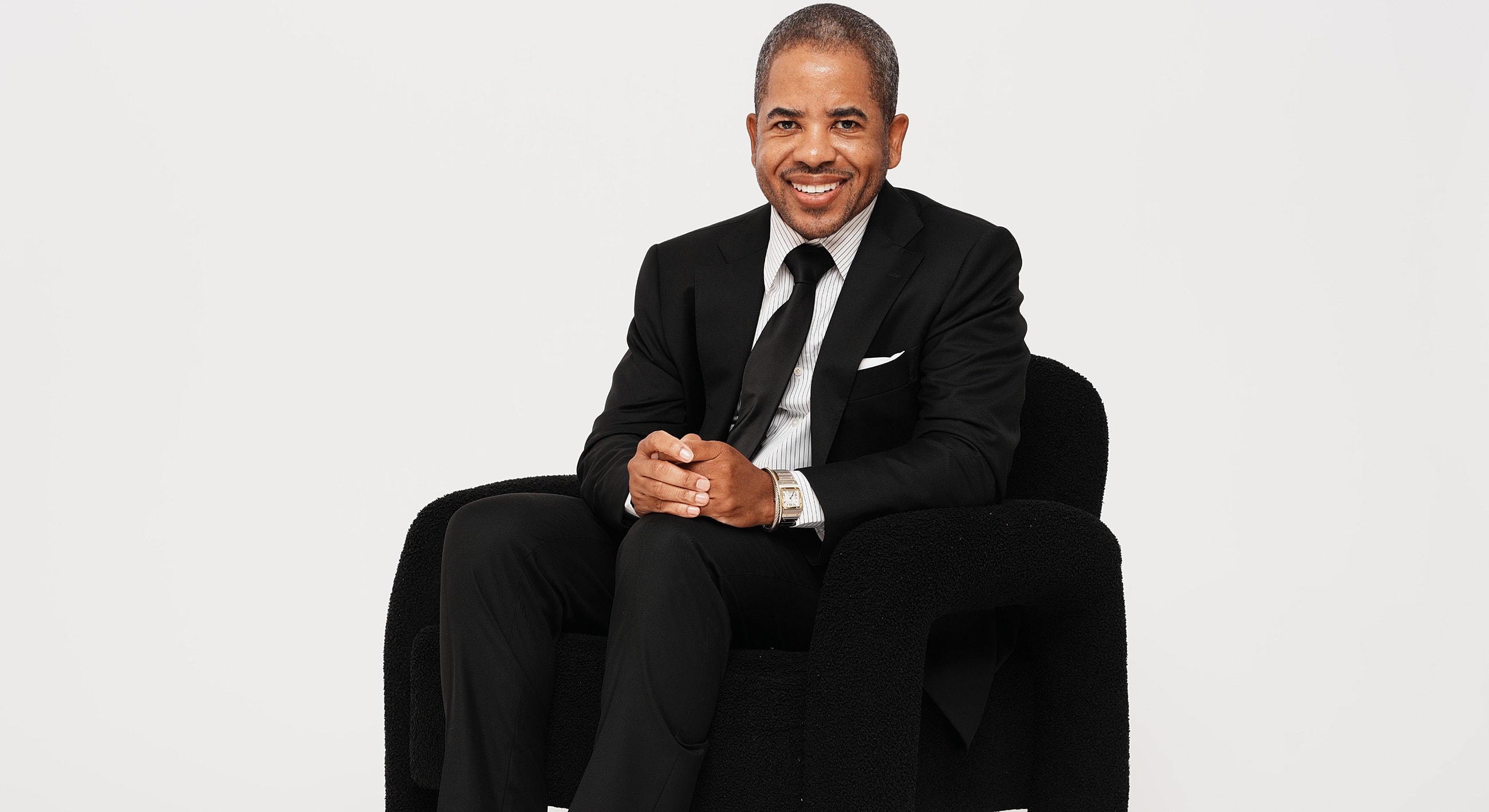Smiling doctor in black scrubs on dark background